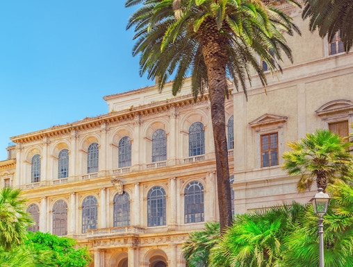 Barberini Palace facade with palm trees, Rome, Italy.