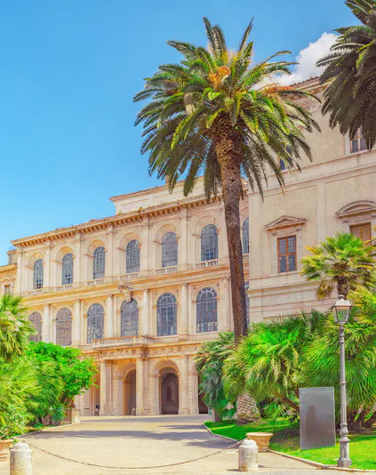 Barberini Palace facade with palm trees, Rome, Italy.