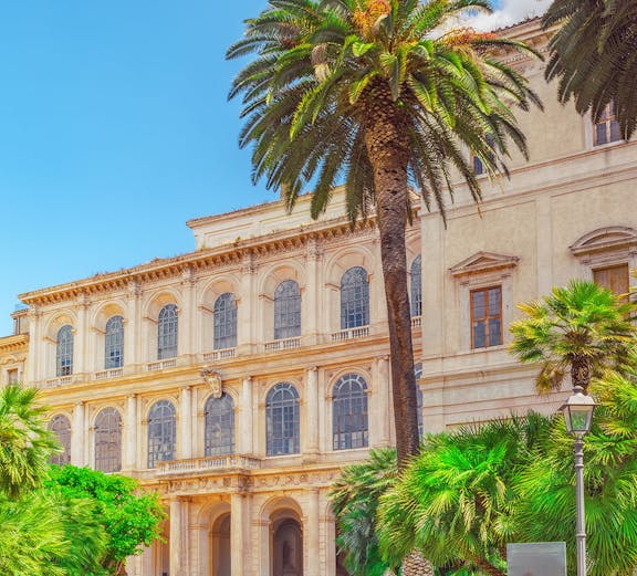 Barberini Palace facade with palm trees, Rome, Italy.