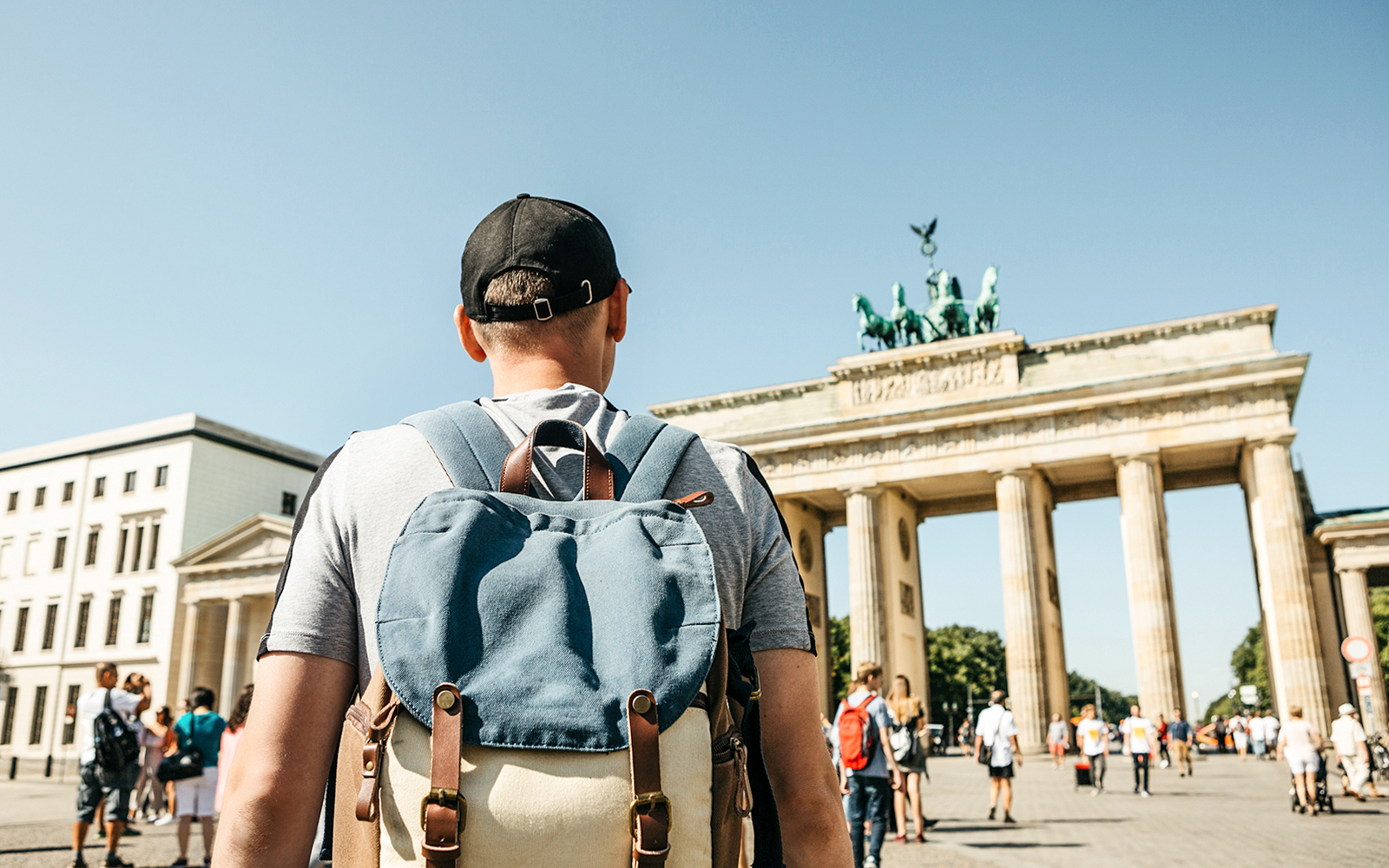 Traveler with backpack at Brandenburg Gate, Berlin.