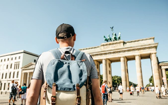 Traveler with backpack at Brandenburg Gate, Berlin.