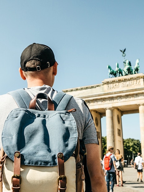 Traveler with backpack at Brandenburg Gate, Berlin.