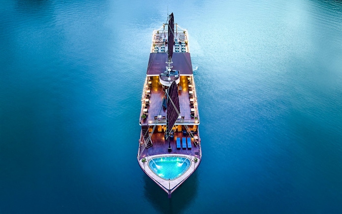 Aerial view of Amanda Luxury Cruise illuminated at night on calm waters.