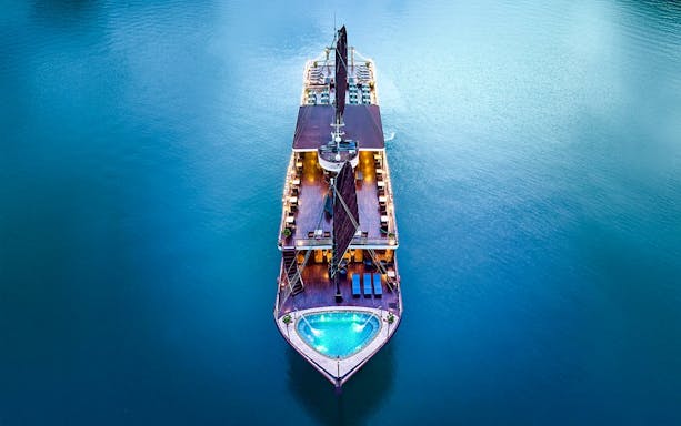 Aerial view of Amanda Luxury Cruise illuminated at night on calm waters.