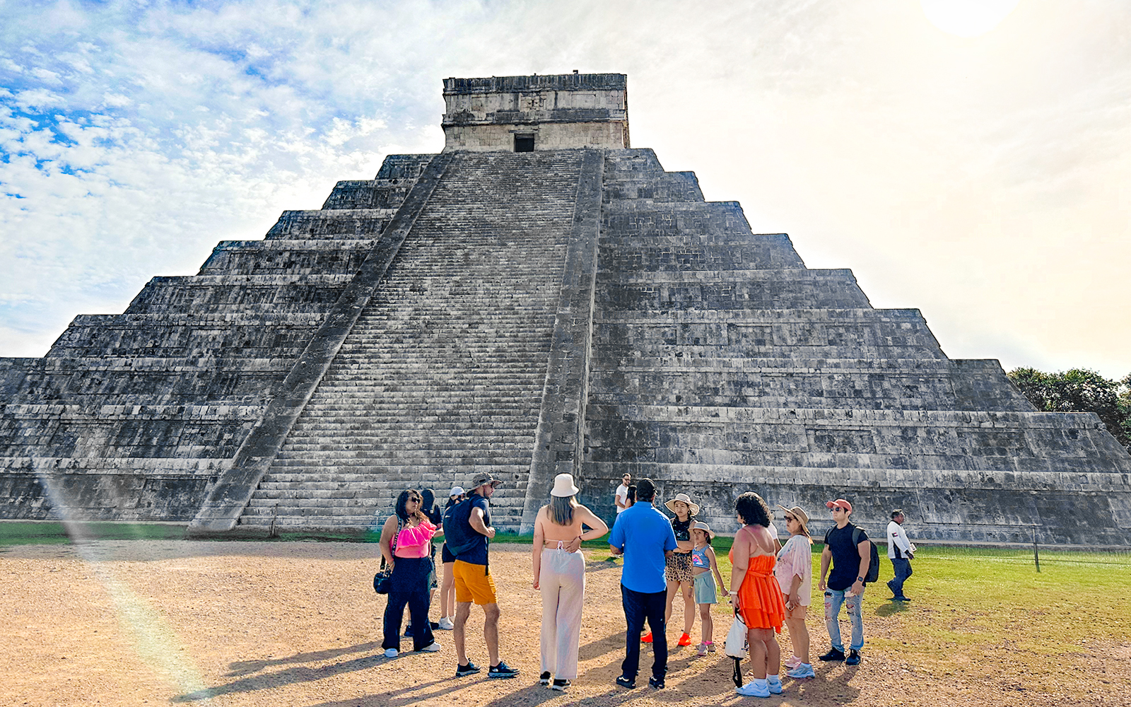 Tourist guide explaining Chichen Itza temple history to visitors in Mexico.