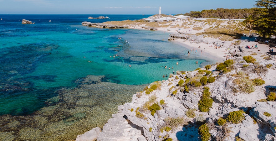 Tourists on Segways exploring Rottnest Island with ferry in background from Perth or Fremantle.