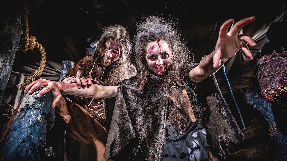 Cannibal Cave exhibit at Edinburgh Dungeon with eerie lighting and historical artifacts.