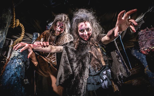 Cannibal Cave exhibit at Edinburgh Dungeon with eerie lighting and historical artifacts.