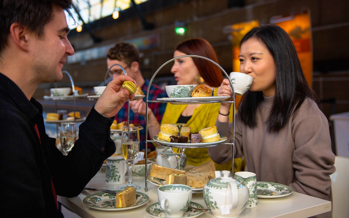 Guests enjoying afternoon tea at Cutty Sark with pastries and tea sets.