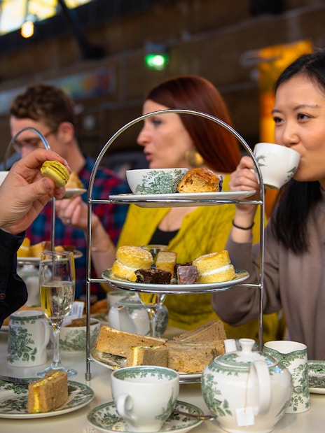 Guests enjoying afternoon tea at Cutty Sark with pastries and tea sets.