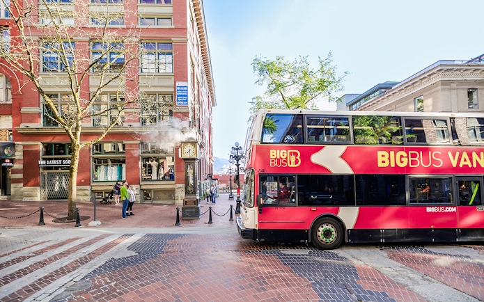 Big Bus Vancouver passing by Gastown Steam Clock in Vancouver.