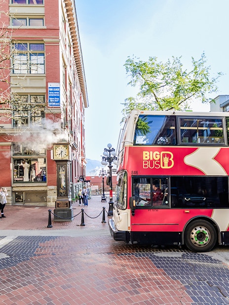 Big Bus Vancouver passing by Gastown Steam Clock in Vancouver.