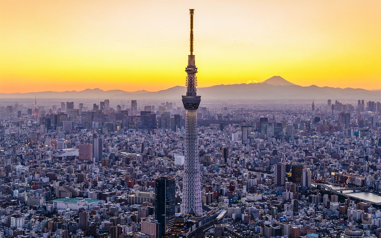 Tokyo Skytree at sunset with cityscape and Mount Fuji in the background.