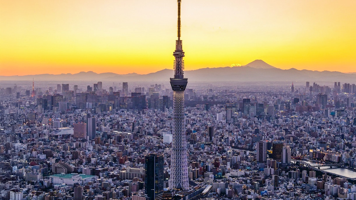 Tokyo Skytree at sunset with cityscape and Mount Fuji in the background.