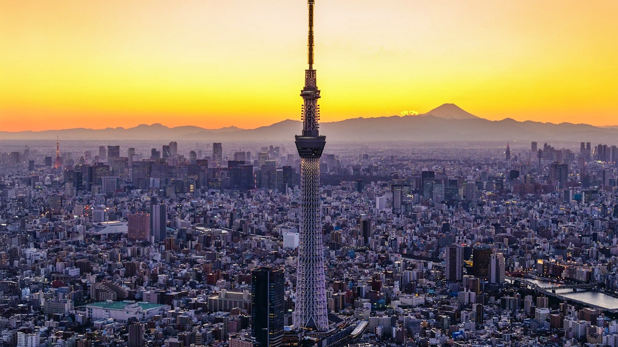 Tokyo Skytree at sunset with cityscape and Mount Fuji in the background.