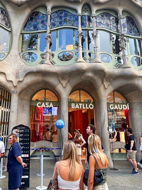 Casa Batlló entrance with visitors in Barcelona, showcasing Gaudí's unique architecture.