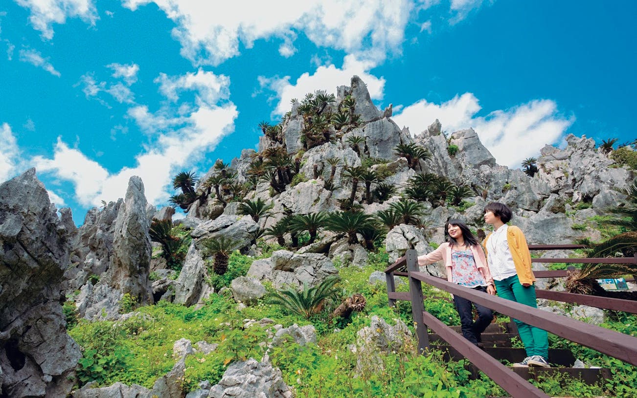 Visitors exploring rocky landscape on Okinawa Hip Hop Bus Tour C Course.