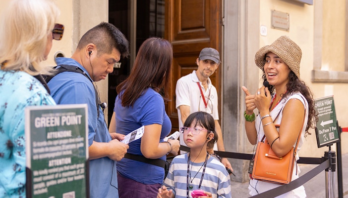 Tour group with guide at Accademia Gallery, Florence, viewing Michelangelo's David statue.
