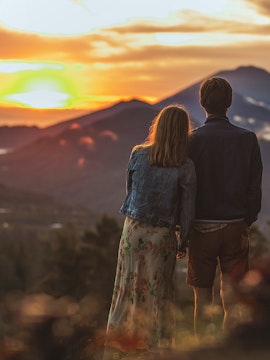 Couple watching sunrise over Mount Batur, Bali.