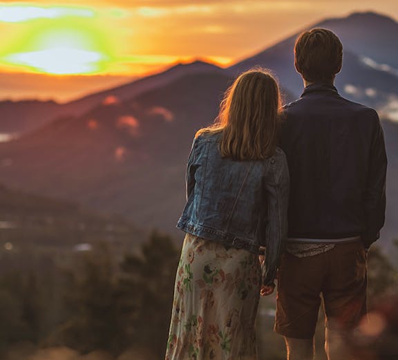 Couple watching sunrise over Mount Batur, Bali.