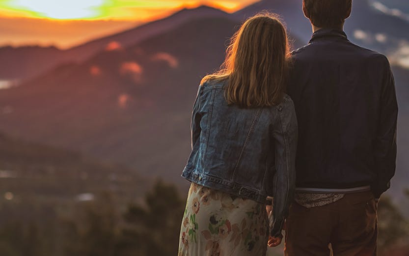 Couple watching sunrise over Mount Batur, Bali.