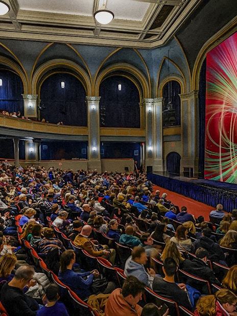 Audience watching a space-themed presentation at the American Museum of Natural History.