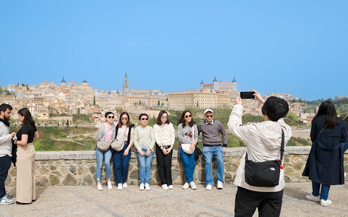 Group posing with Toledo skyline in background on express tour from Madrid.