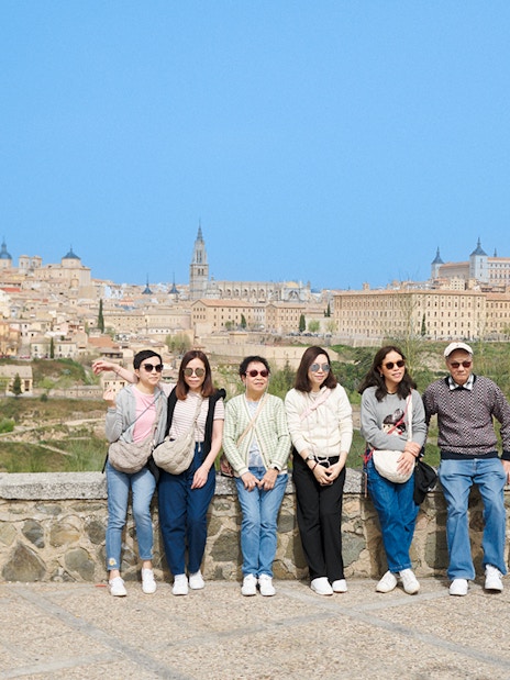 Group posing with Toledo skyline in background on express tour from Madrid.