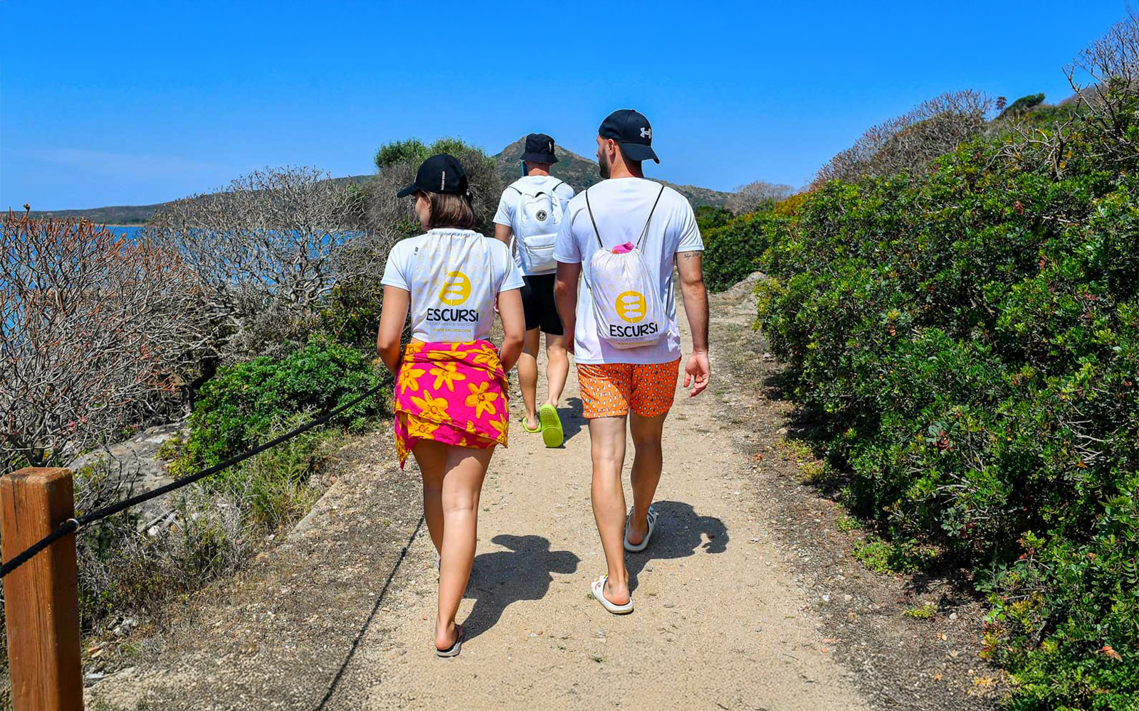 Group walking on a path during a wooden sailboat excursion to Asinara Island.