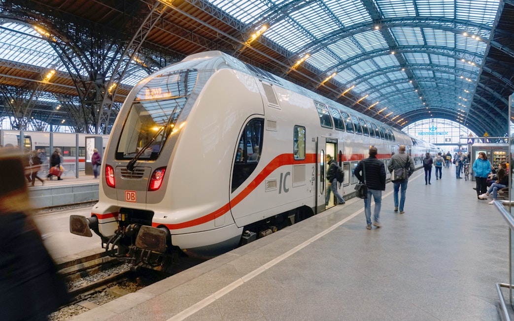 Euro Rail train at a German station platform with passengers boarding.