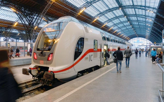 Euro Rail train at a German station platform with passengers boarding.