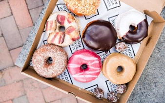 Assorted donuts in a box on a Boston guided donut tour with tastings.