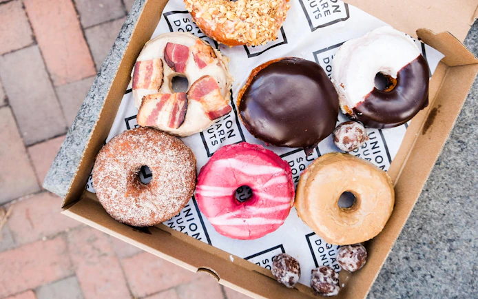 Assorted donuts in a box on a Boston guided donut tour with tastings.