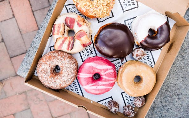 Assorted donuts in a box on a Boston guided donut tour with tastings.
