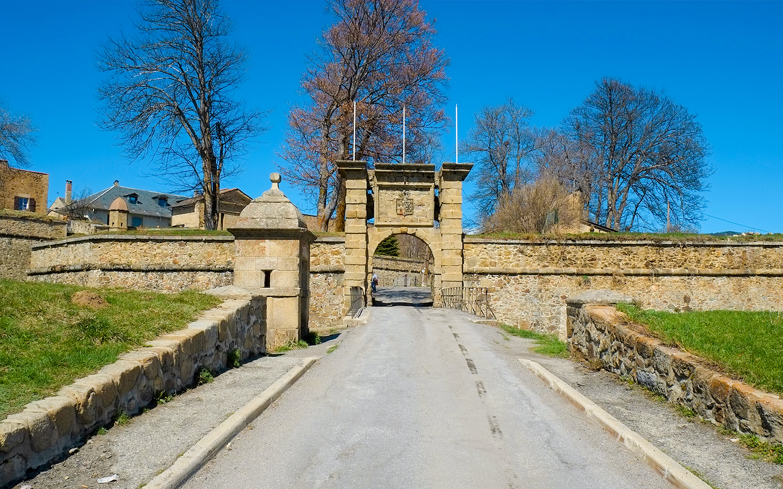 Gates to medieval fortress at Mont Louis, France, with stone walls and archway.