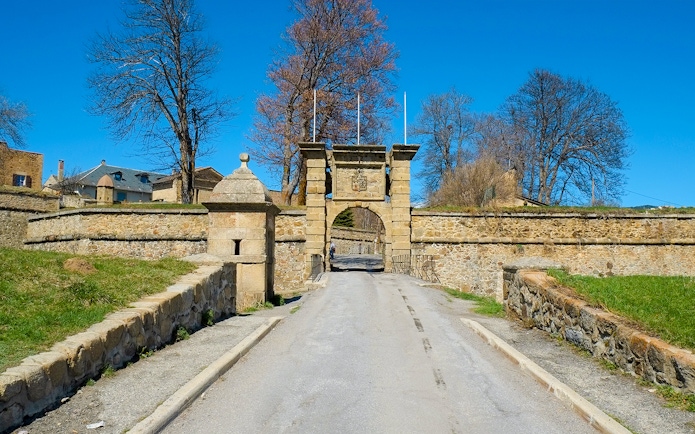 Gates to medieval fortress at Mont Louis, France, with stone walls and archway.