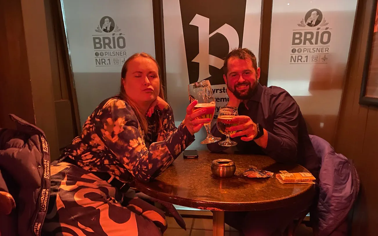 People enjoying drinks at a bar in Reykjavík during a private bar crawl.