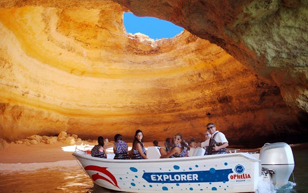 Catamaran tour exploring Benagil Caves with passengers near Portimão.