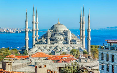 Blue Mosque exterior with minarets and domes, Istanbul skyline in background.