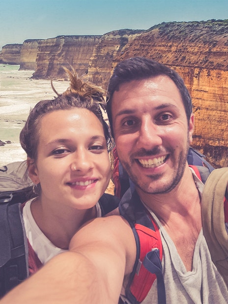 Couple taking a selfie with the 12 Apostles rock formations on the Great Ocean Road, Australia.