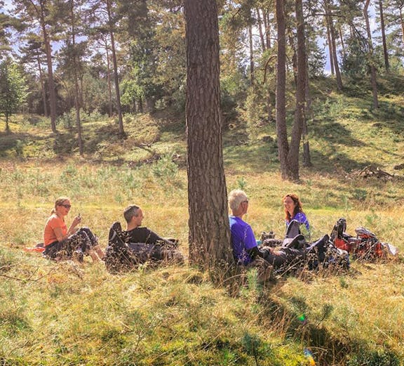 Group relaxing under trees in Hoge Veluwe National Park.
