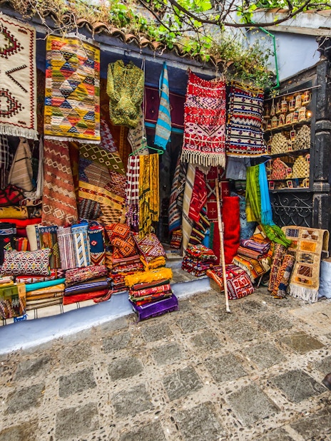 Colorful textiles displayed in a market in Chefchaouen, Morocco.