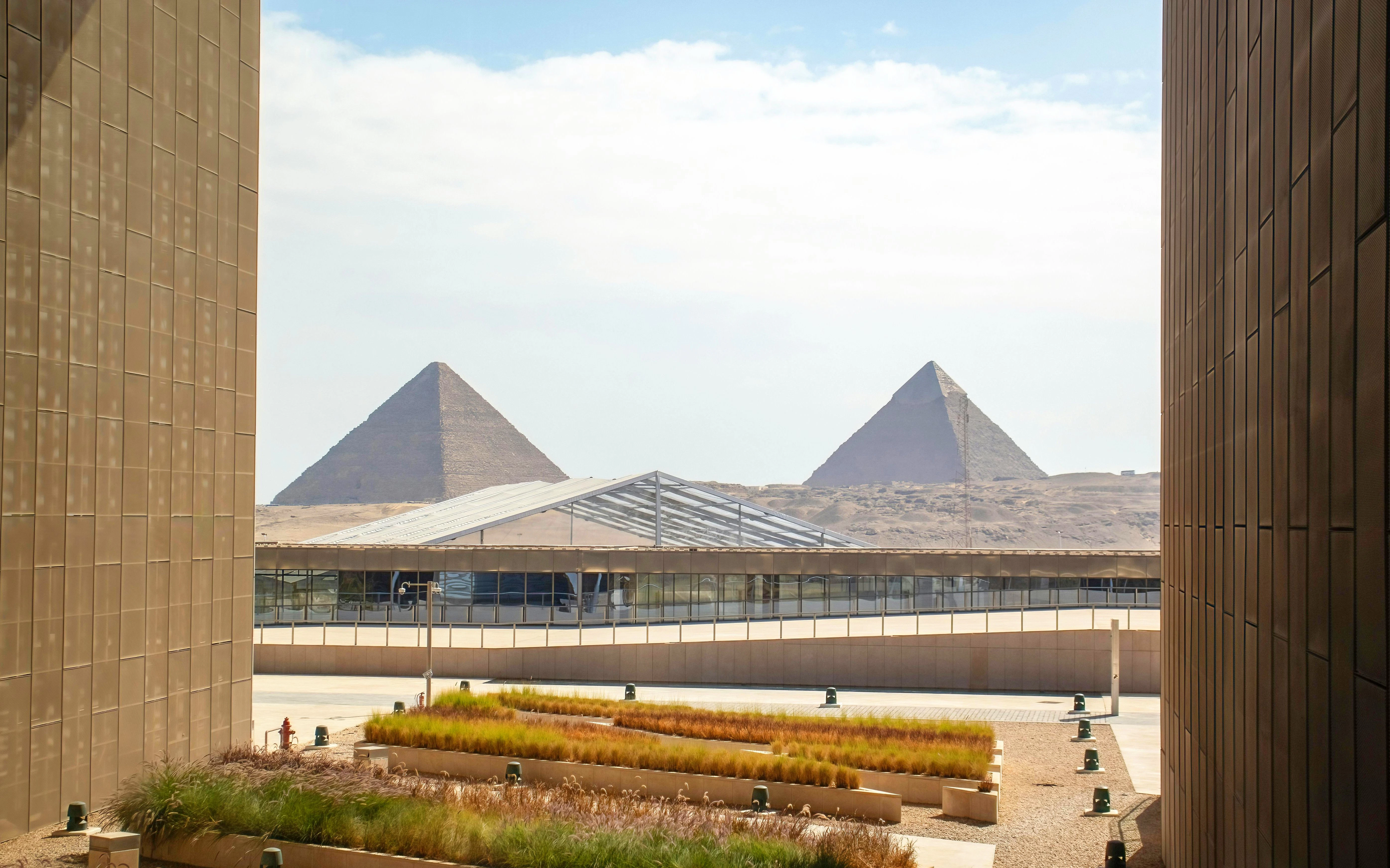 Great Pyramid of Giza viewed from Grand Egyptian Museum terrace with landscaped foreground.