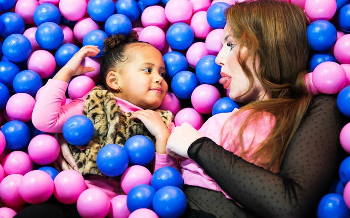 Adults and child playing in a colorful ball pit at Youseum.