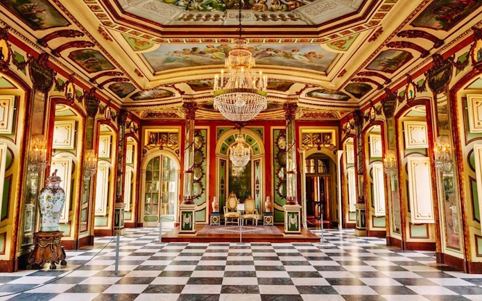 Interior of National Palace of Queluz with ornate chandeliers and decorative ceiling.