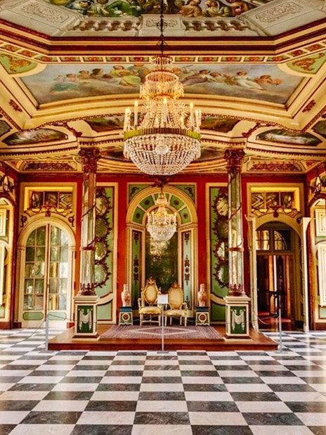 Interior of National Palace of Queluz with ornate chandeliers and decorative ceiling.