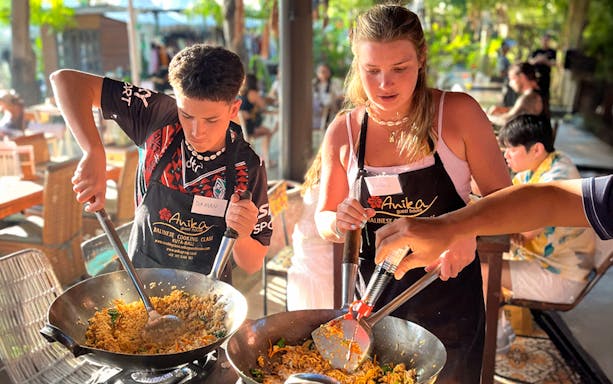 Participants cooking at Nia Balinese Cooking Class in Kuta, Bali.
