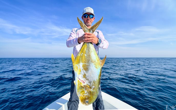 Man holding a large fish on a deep sea fishing charter.