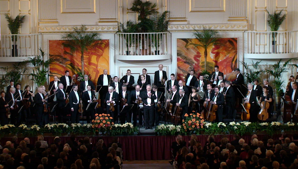 Vienna Hofburg Orchestra performing in a grand concert hall.