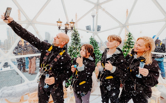 Guests enjoying the Up at the O2 Snow Globe Experience in winter gear.